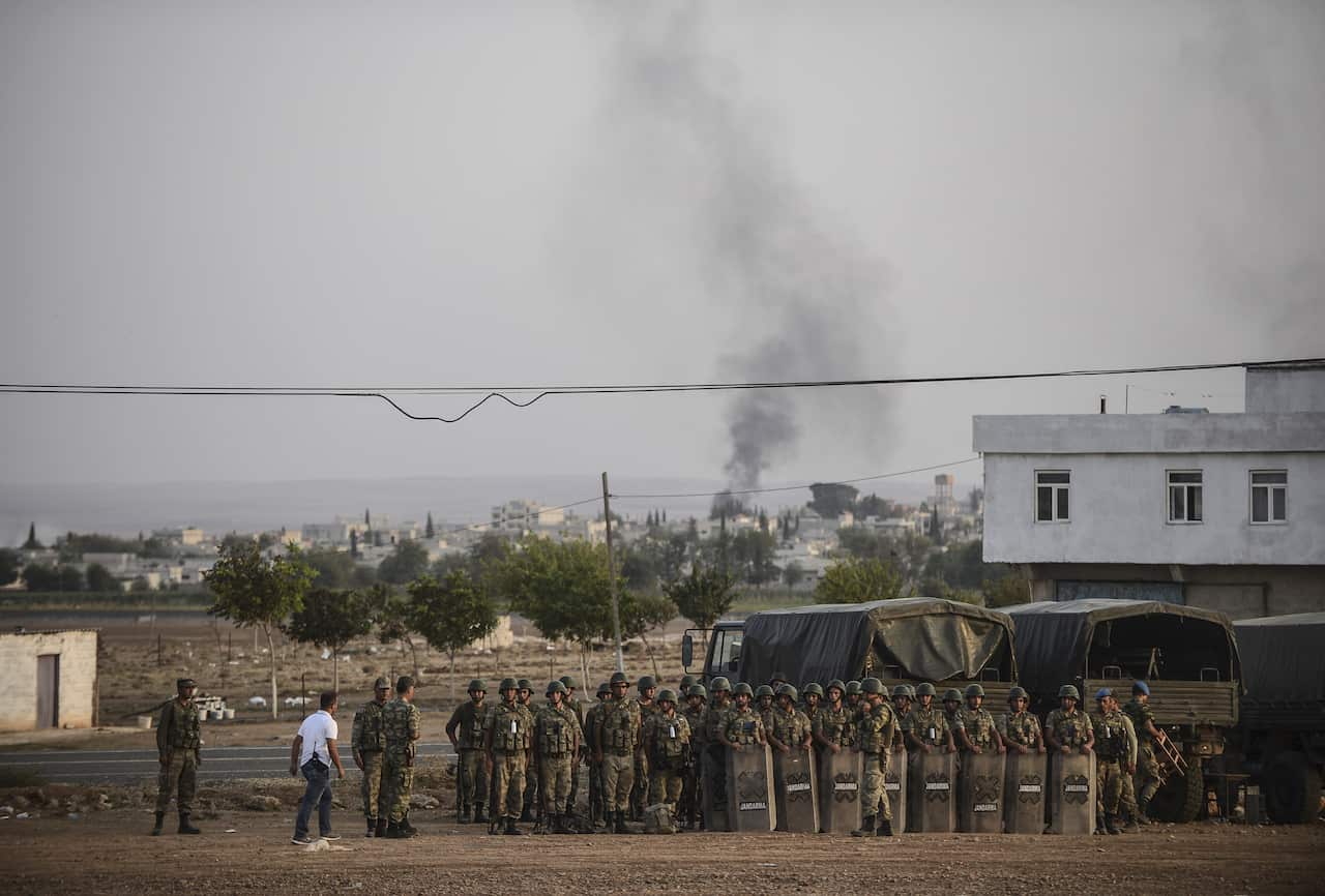Smoke rises from the Syrian town of Ain al-Arab, known as Kobane by the Kurds, as Turkish soldiers take position in the southeastern town of Suruc, Sanliurfa province, near the Mursitpinar border crossing with Syria on October 3, 2014. (AFP/Getty)