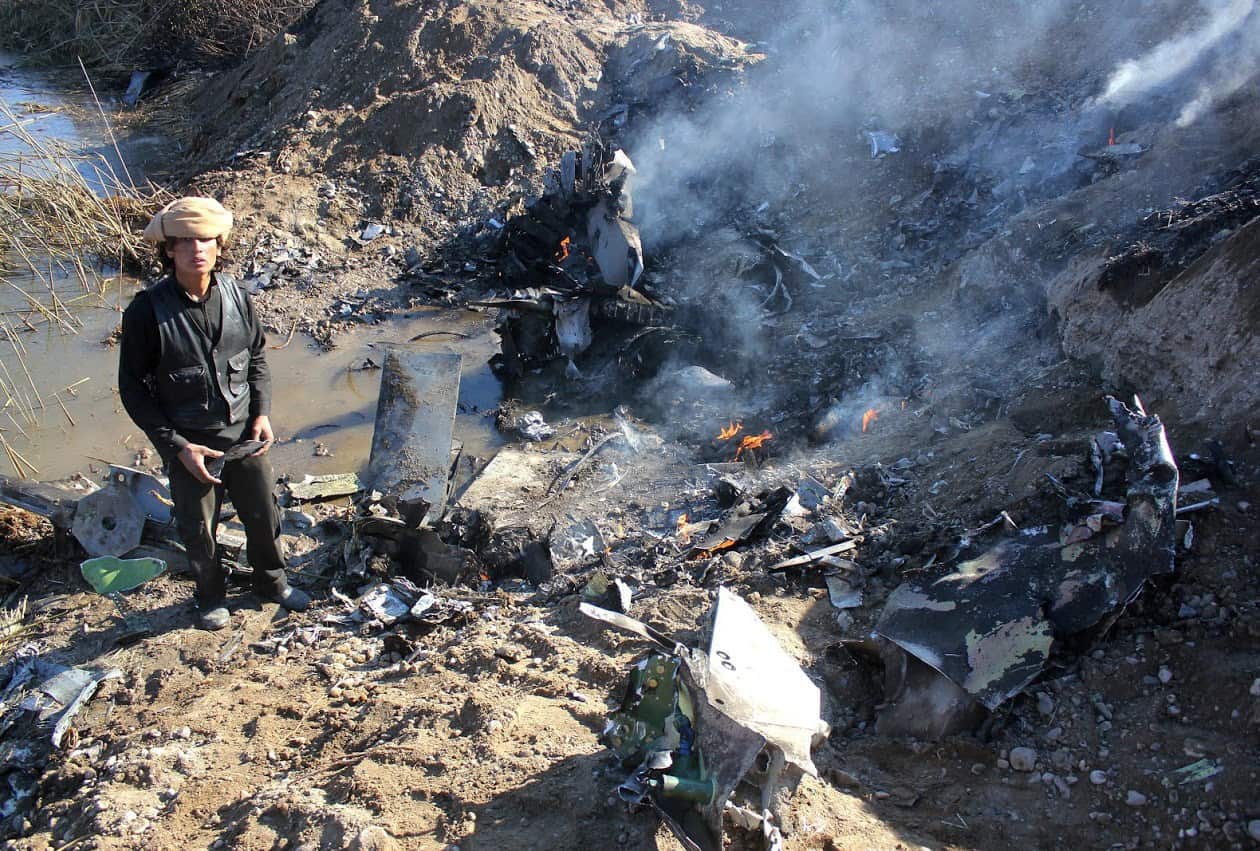 A picture taken on December 24, 2014 reportedly shows an Islamic State group fighter collecting pieces from the remains of a Jordanian warplane from the US led coalition after it was shot down in Syria's Raqa region. (AAP)