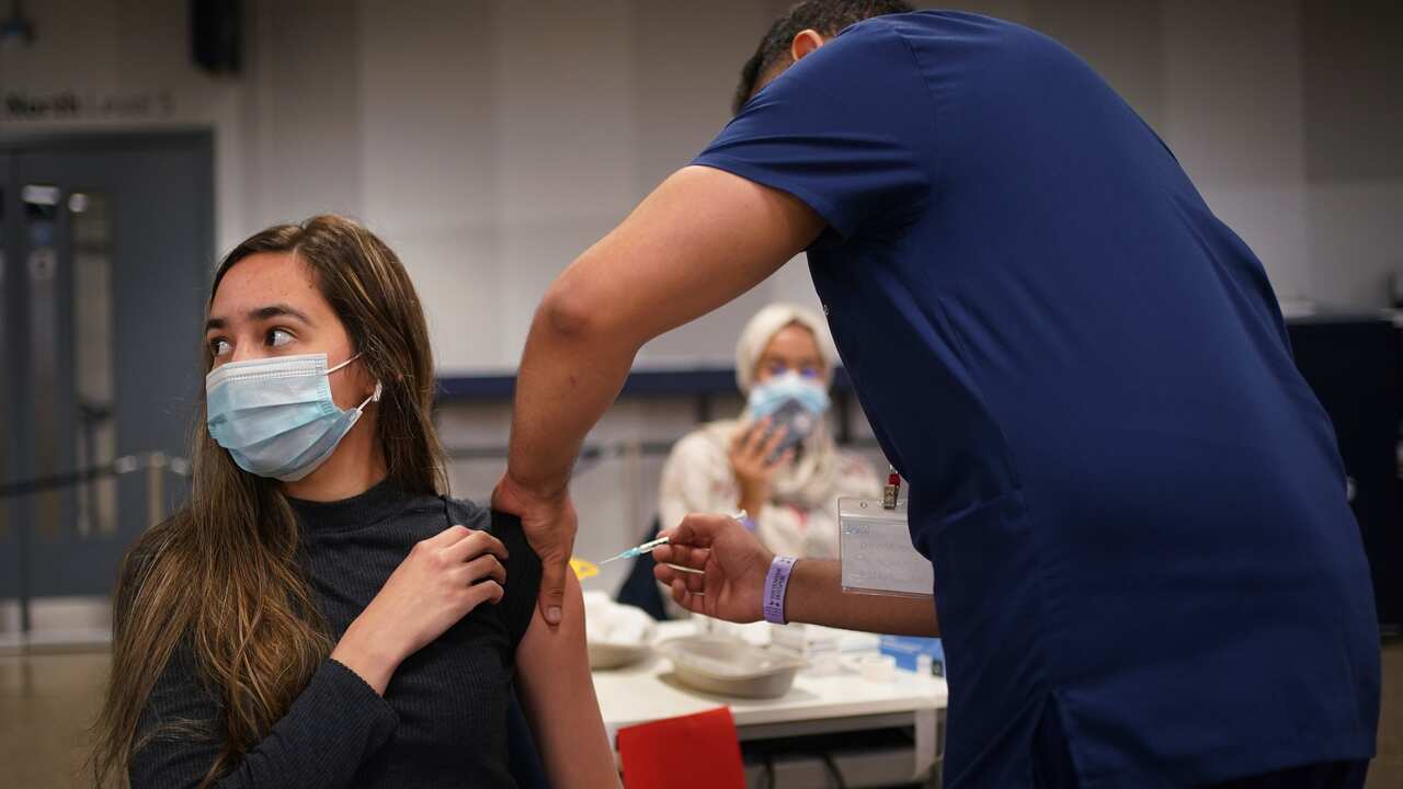 a woman receiving a Pfizer BioNTech COVID-19 vaccine at an NHS Vaccination Clinic at Tottenham Hotspur's stadium in north London. 