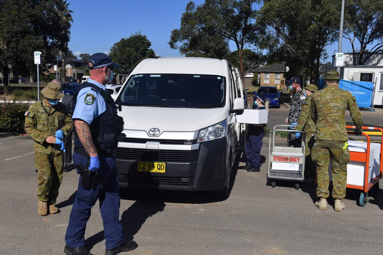 Australian Defence Force personnel and NSW police load emergency food parcels for people in lockdown in the south west of Sydney, Monday, August 2, 2021.