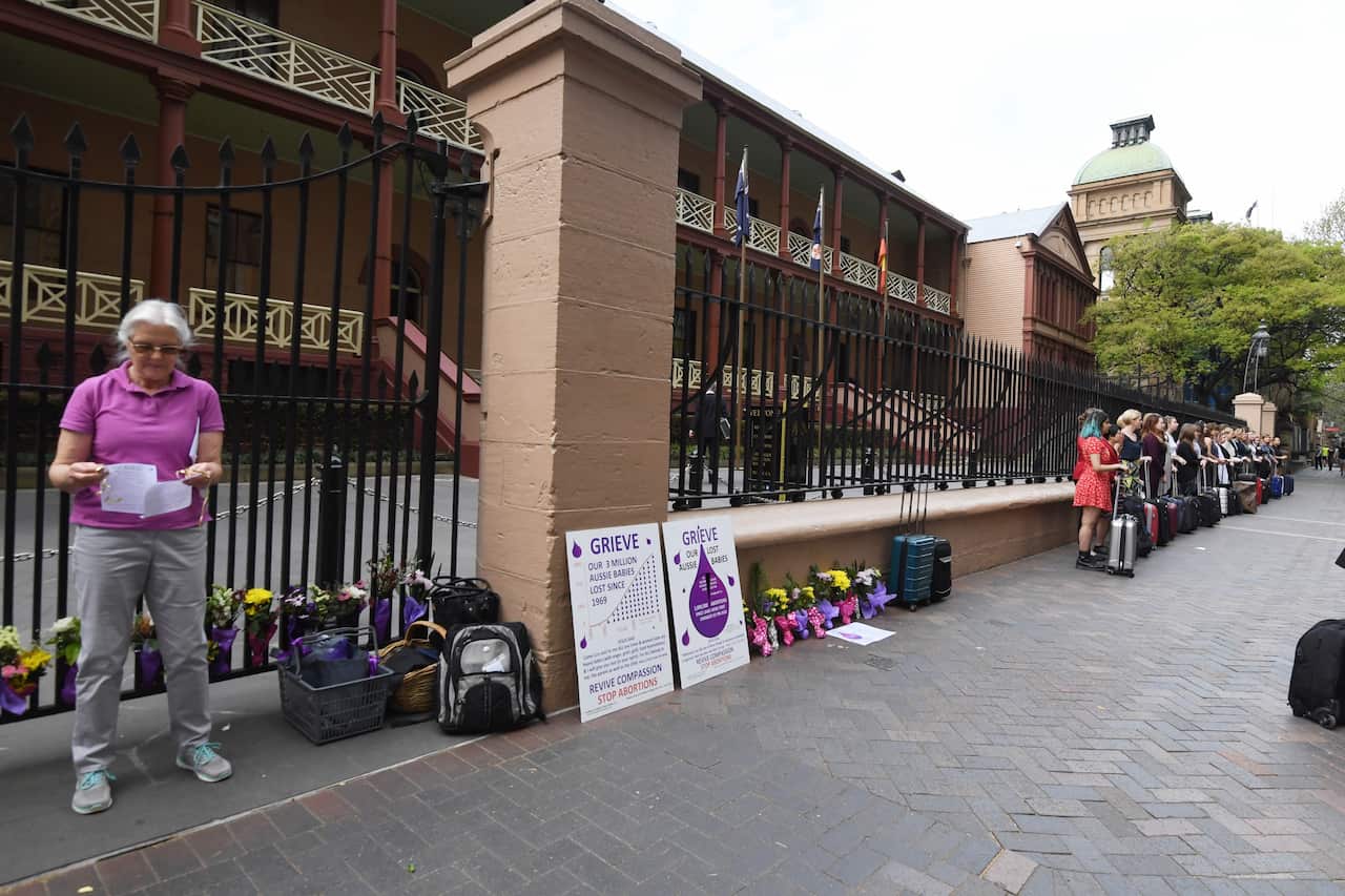 Anti-abortion protestors are seen alongside members of the NSW Pro-Choice Alliance outside NSW Parliament House.