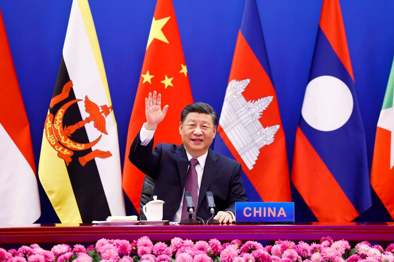 In this photo released by Xinhua News Agency, Chinese President Xi Jinping waves as he chairs the ASEAN-China Special Summit to commemorate the 30th Anniversary of ASEAN-China Dialogue Relations via video link from Beijing, China on Monday, Nov. 22, 2021.