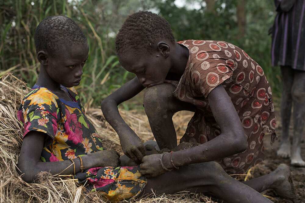 Children remove thorns from each others' feet. (Matthew Abbott)