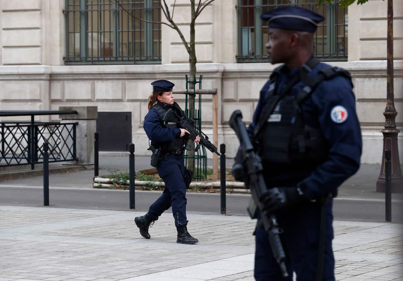 French police and security forces establish a security perimeter near the police headquarters where a man was attacking officers with a knife in Paris
