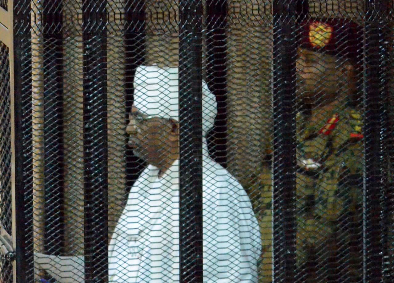 Sudan's ousted president Omar Hassan al-Bashir (L) stands in a cage during his trial at a courtroom in Khartoum, Sudan, 19 August 2019.