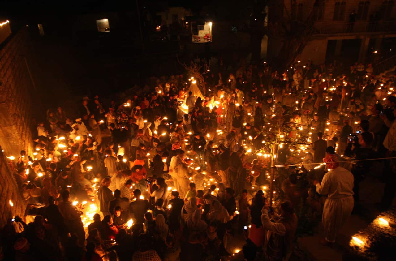 Iraqi Yazidis light candles during celebrations for the Yazidi New Year