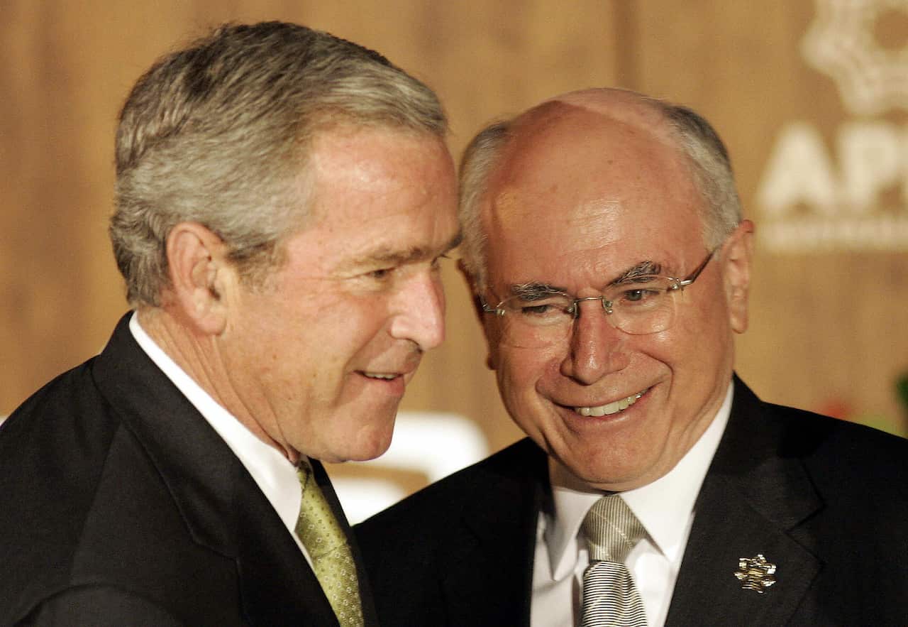 John Howard and George Bush smile.