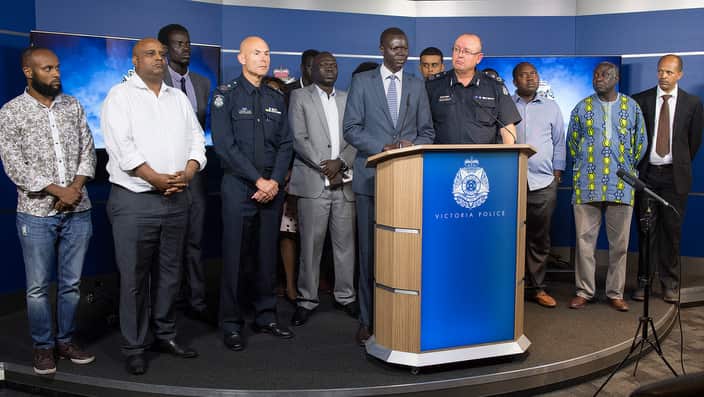 An African community leaders speaks to the media and Victorian Chief Police Commissioner Graham Ashton during a press conference