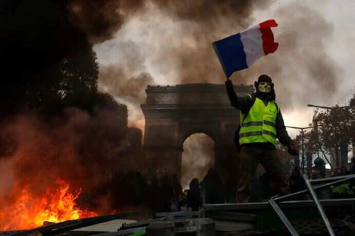 Yellow vests (Gilets jaunes) protest against rising oil prices and living costs near the Arc de Triomphe on the Champs Elysees in Paris.