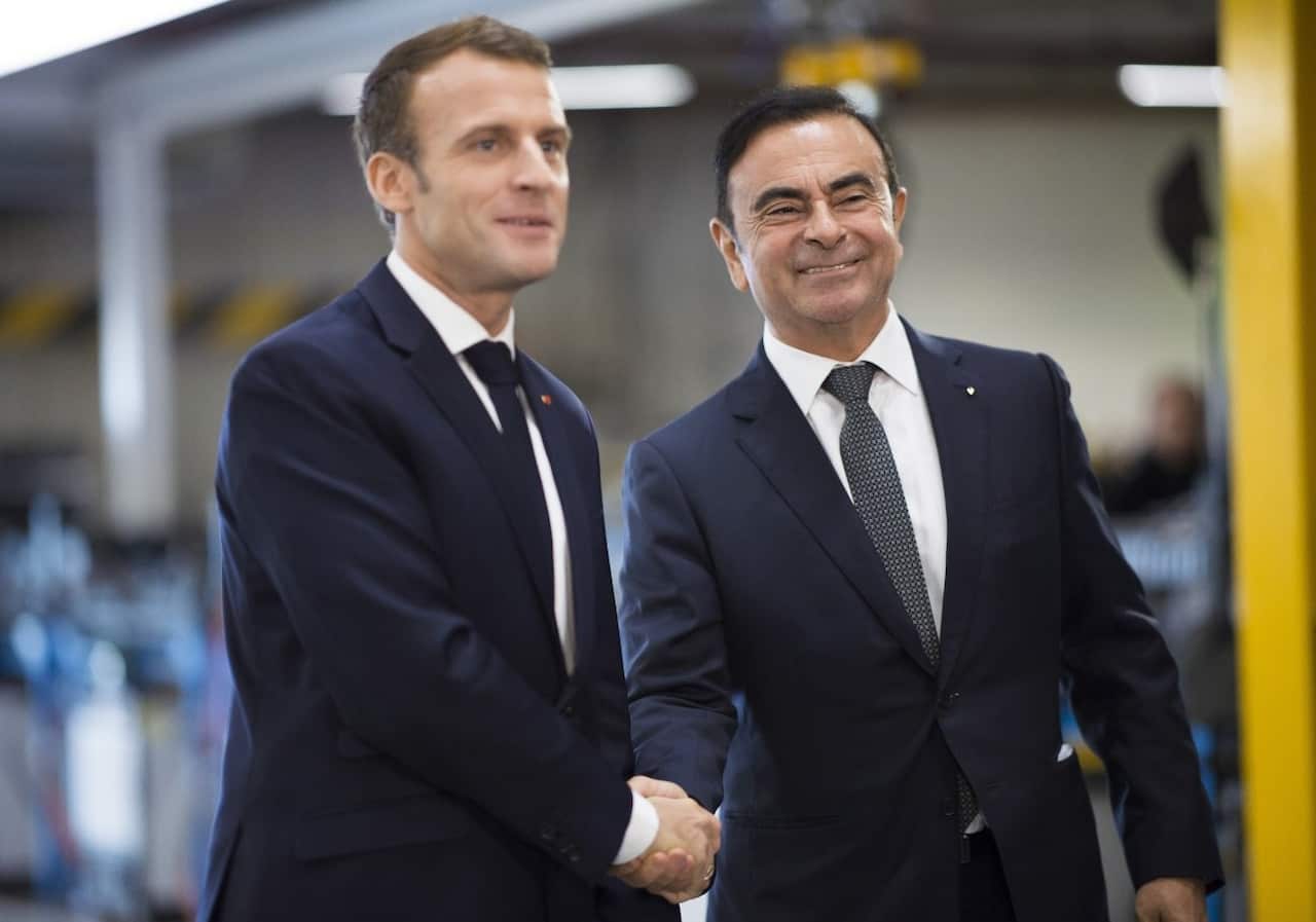 French President Emanuel Macron (R) shakes hands with Chairman and CEO of Renault-Nissan-Mitsubishi Carlos Ghosn on November 8