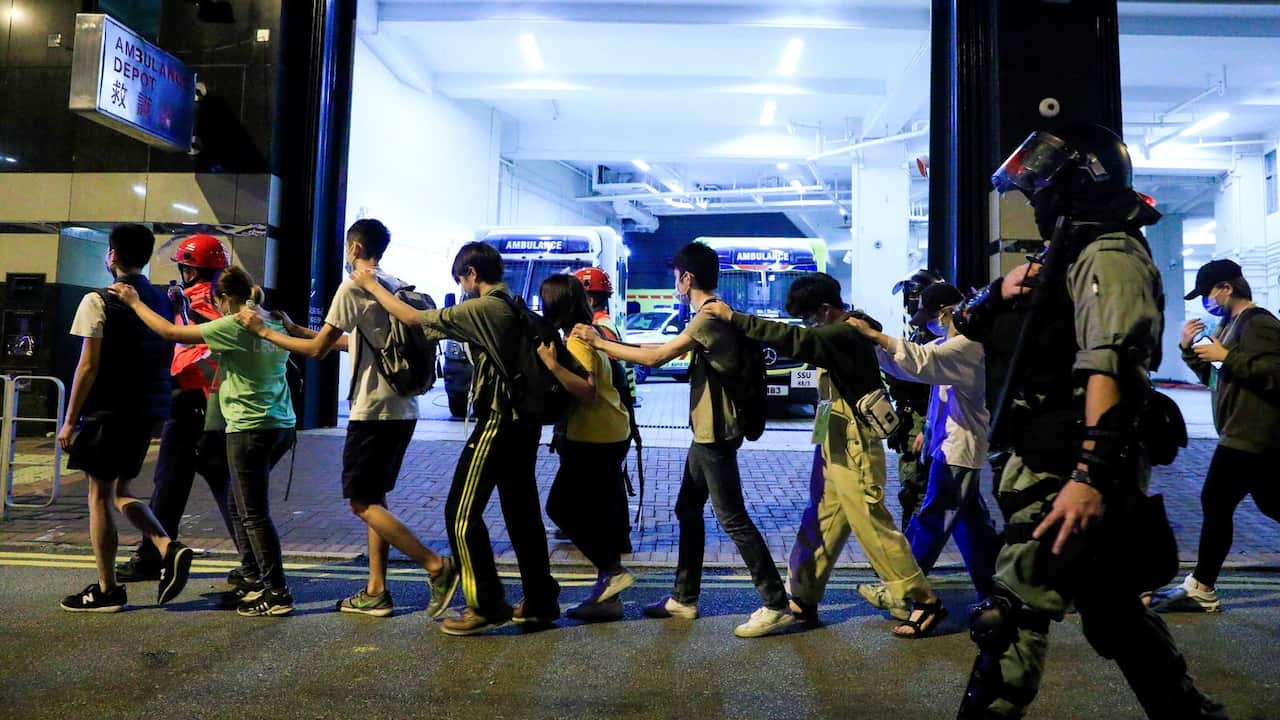 Protesters are escorted by police out of the campus of Hong Kong Polytechnic University during clashes with police in Hong Kong on Monday.