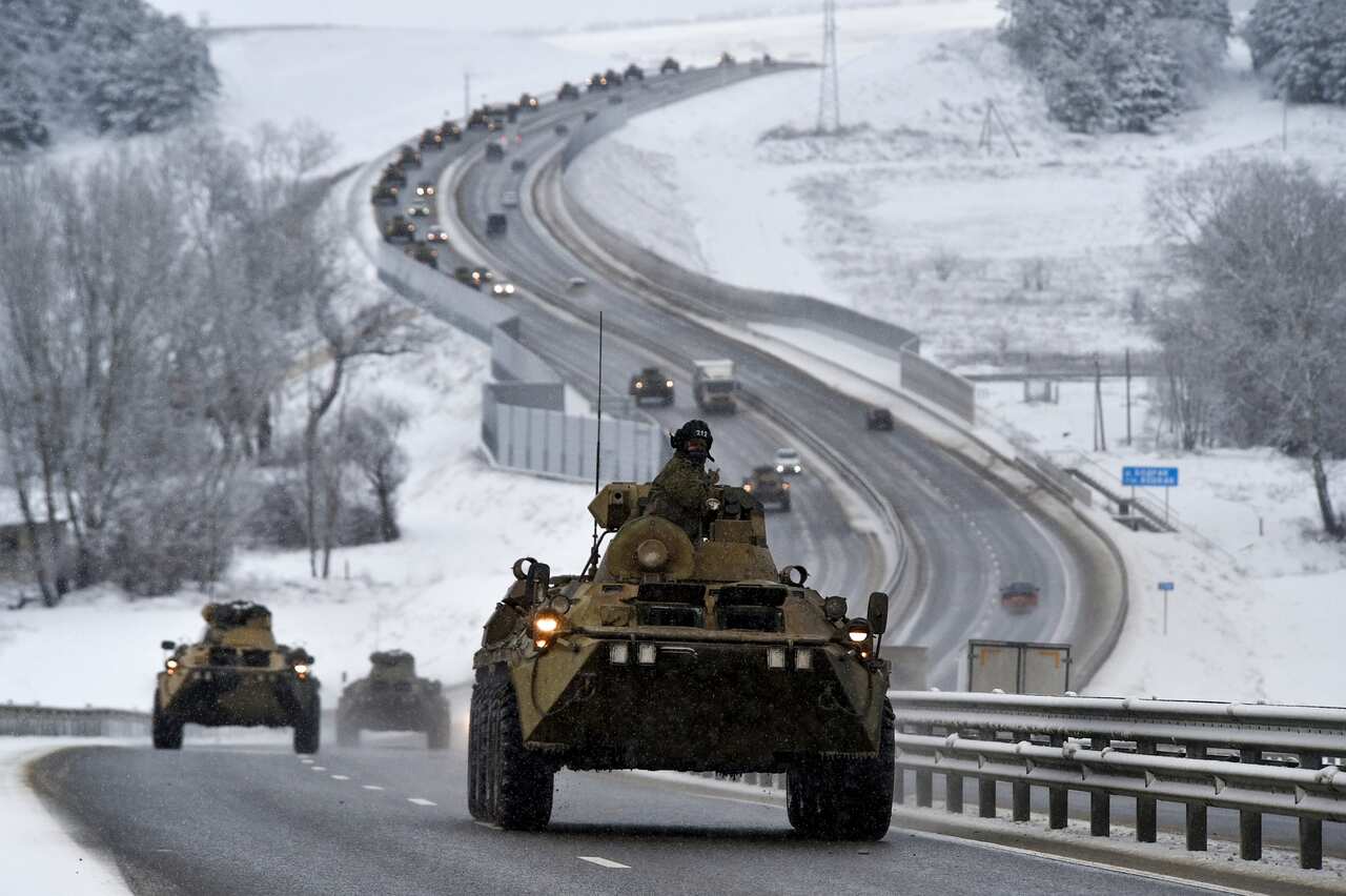A tank on a road lined by snow