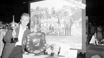 Bennie Mollee, captain of the Hollandia soccer team, in 1964 with some of the trophies that the club has won - NAA-1.jpg