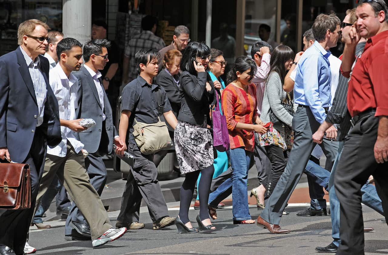 Pedestrians walk across the street