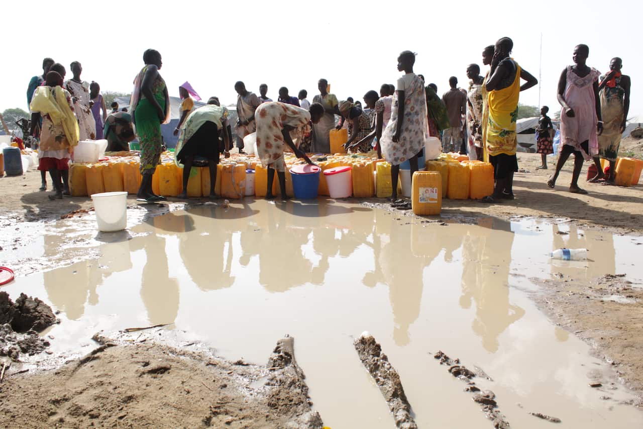 South Sudanese women collect water in the United Nations base camp in Bor, Jonglei state. More than 5,000 mostly Nuer tribe are living inside the compound after the government retook the town. (Ilya Gridneff)