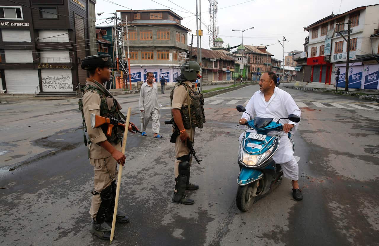 Indian paramilitary soldiers stop a Kashmiri man on a scooter during curfew in Srinagar, the summer capital of Indian Kashmir, 07 August 2019.  EPA/FAROOQ KHAN