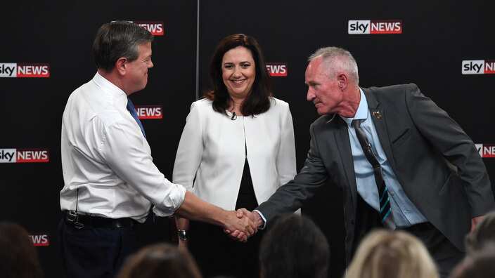 Queensland Premier Annastacia Palaszczuk watches Leader of the Opposition Tim Nicholls shaking hands with One Nation's Steve Dickson during the debate.  