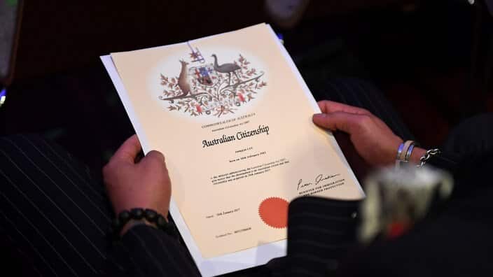An Australian citizenship recipient holds his certificate during a citizenship ceremony on Australia Day in Brisbane, Thursday, Jan. 26, 2017. (AAP Image/Dan Peled) NO ARCHIVING