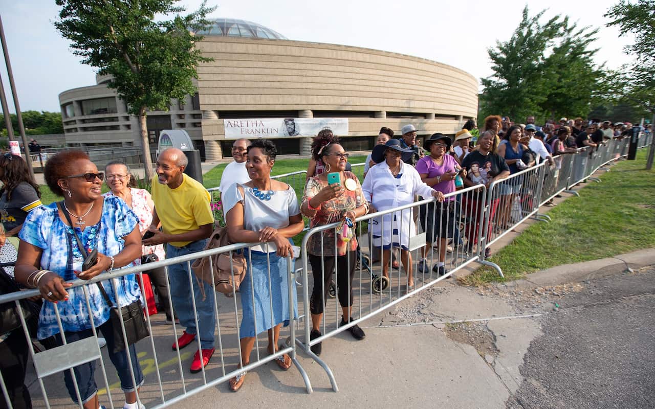 Fans gather outside the Charles H. Wright Museum of African American History as they wait to view the remains of Aretha Franklin in Detroit