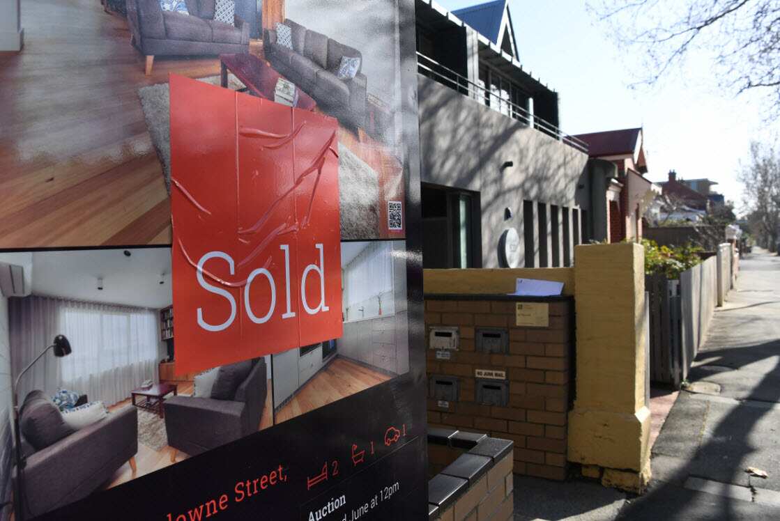 A sign outside a property with a "sold" sticker on it.