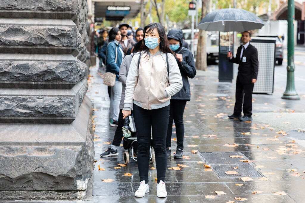  International Students are seen lined up outside the Melbourne Town Hall for food vouchers. 