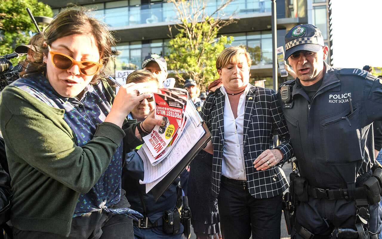 Christine Forster caught up in a crowd of protesters outside a fundraising event for her brother Tony Abbott in Redfern.