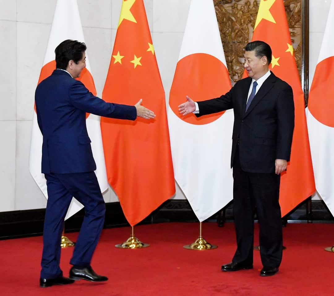 Chinese President Xi Jinping (R) greets Japanese Prime Minister Shinzo Abe prior to their talks in Beijing on Oct. 26, 2018. (Kyodo via AP Images) ==Kyodo