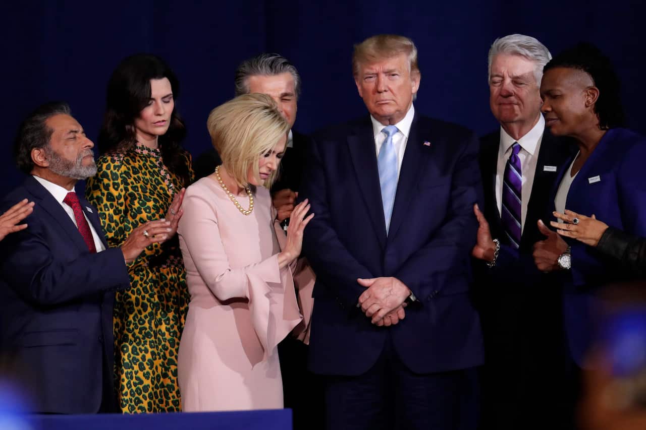 Faith leaders pray with President Trump during an  evangelical rally. Mr Trump has become the first sitting president to attend the March for Life rally. 