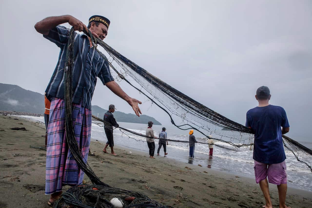 Fishermen pul nets on the coastline in Lamtutui village on December 25, 2014 in Banda Aceh, Indonesia. (Getty)
