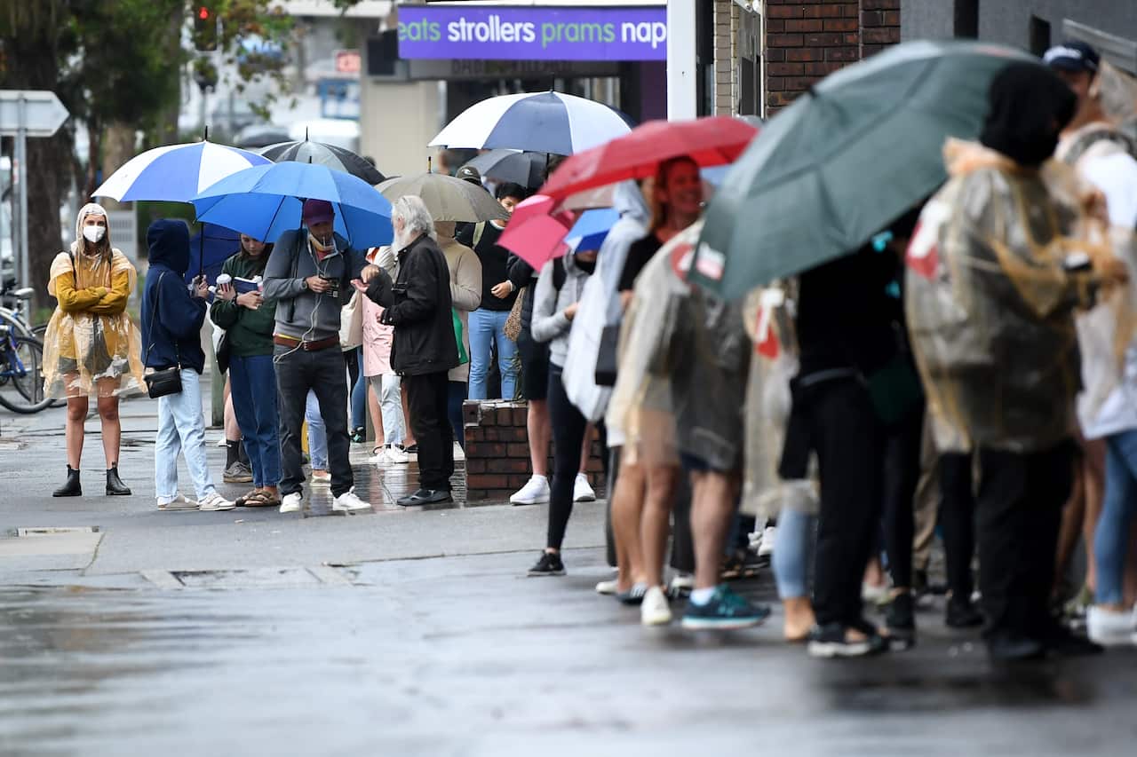 People are seen queuing outside a Centrelink office in Bondi Junction, Sydney, Tuesday, March 24, 2020. 