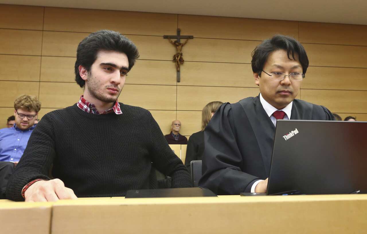 Anas Modamani, left, sits next to his lawyer Jun Chan-jo at the regional court in Wuerzburg, Germany, Monday Feb. 6, 2017. 