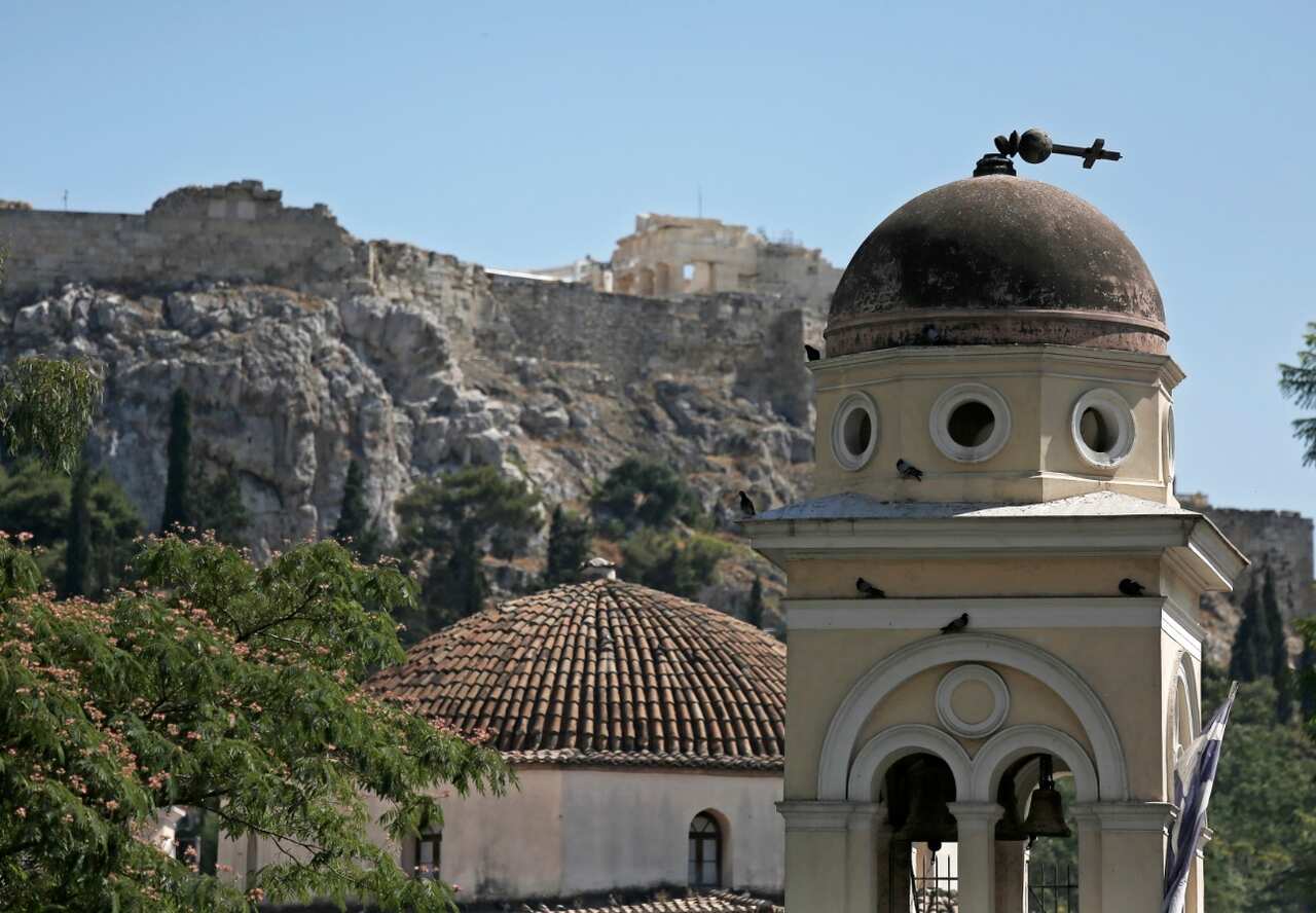 The marble cross of the church of the Pantanassa sits half-broken on the temple's dome in Monastiraki Square