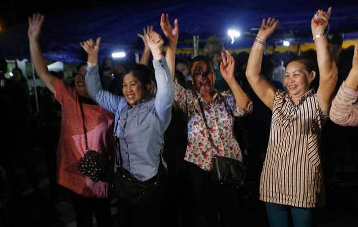 People celebrate the rescue of the 12 boys and their coach who were trapped in Tham Luang cave.