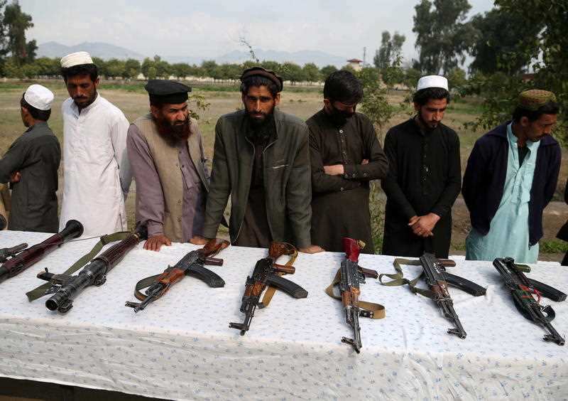 Former Taliban and IS fighters surrender their weapons during a reconciliation ceremony. Militants have come to the table to talk an end to conflict.