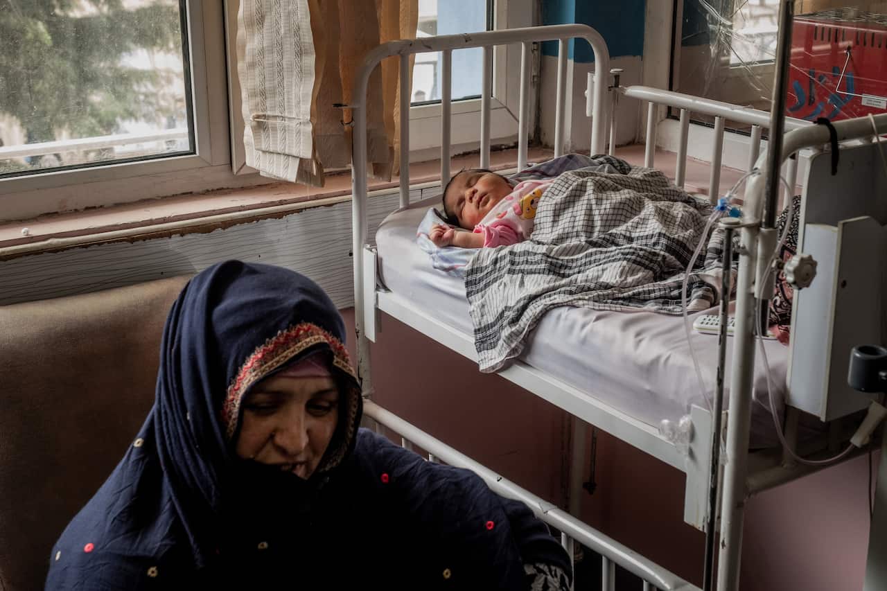 Gul Makai, sits with her baby at Ataturk hospital in Kabul, Afghanistan, Wednesday, May 13, 2020, a day after an attack on another hospital, which she escaped. (Jim Huylebroek/The New York Times)