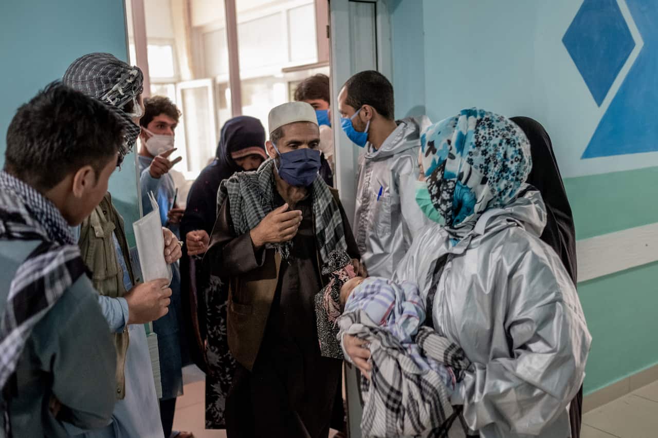 Azizullah, center, and his wife Gul Makai, behind him, depart Ataturk hospital, in Kabul, Afghanistan, Wednesday, May 13, 2020, a day after an attack on another hospital. (Jim Huylebroek/The New York Times)