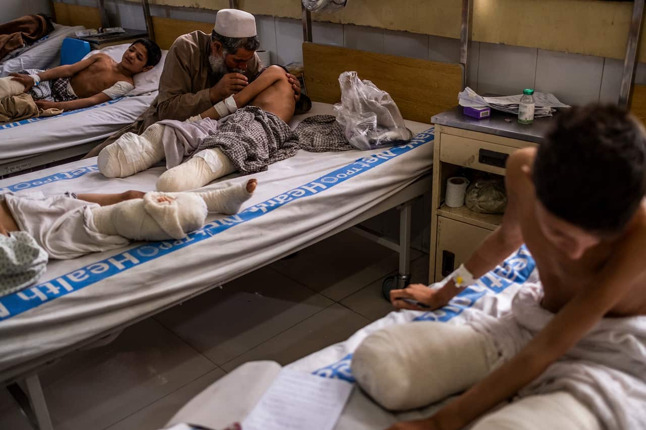 Hamisha Gul comfort his son, Abdul Rashid, 12, as Shafiqullah, 13, does schoolwork in his hospital bed at Nangarhar Regional Hospital in Jalalabad, Afghanistan.
