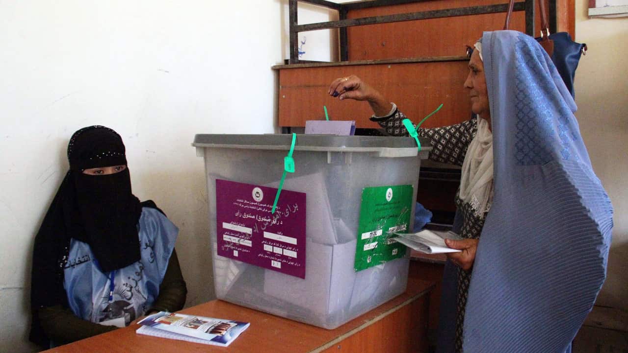 An Afghan woman casts her vote at a polling station during parliamentary elections in Helmand, Afghanistan.