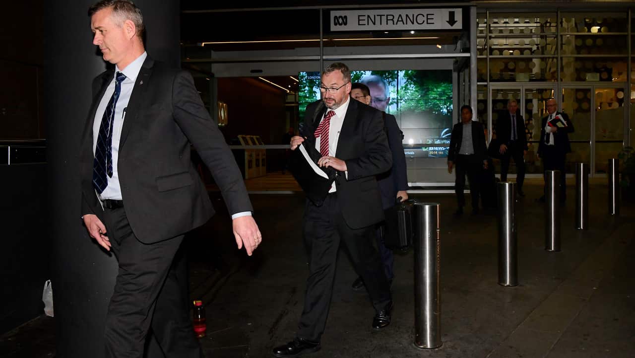 Australian Federal Police (AFP) investigators  leaving the main entrance to the ABC building at Ultimo in Sydney.