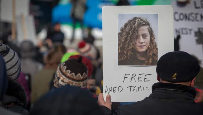 A protester holds a placard depicting Ahed Tamimi as hundreds take part in the Women's March on January 20, 2018 in Montreal. 