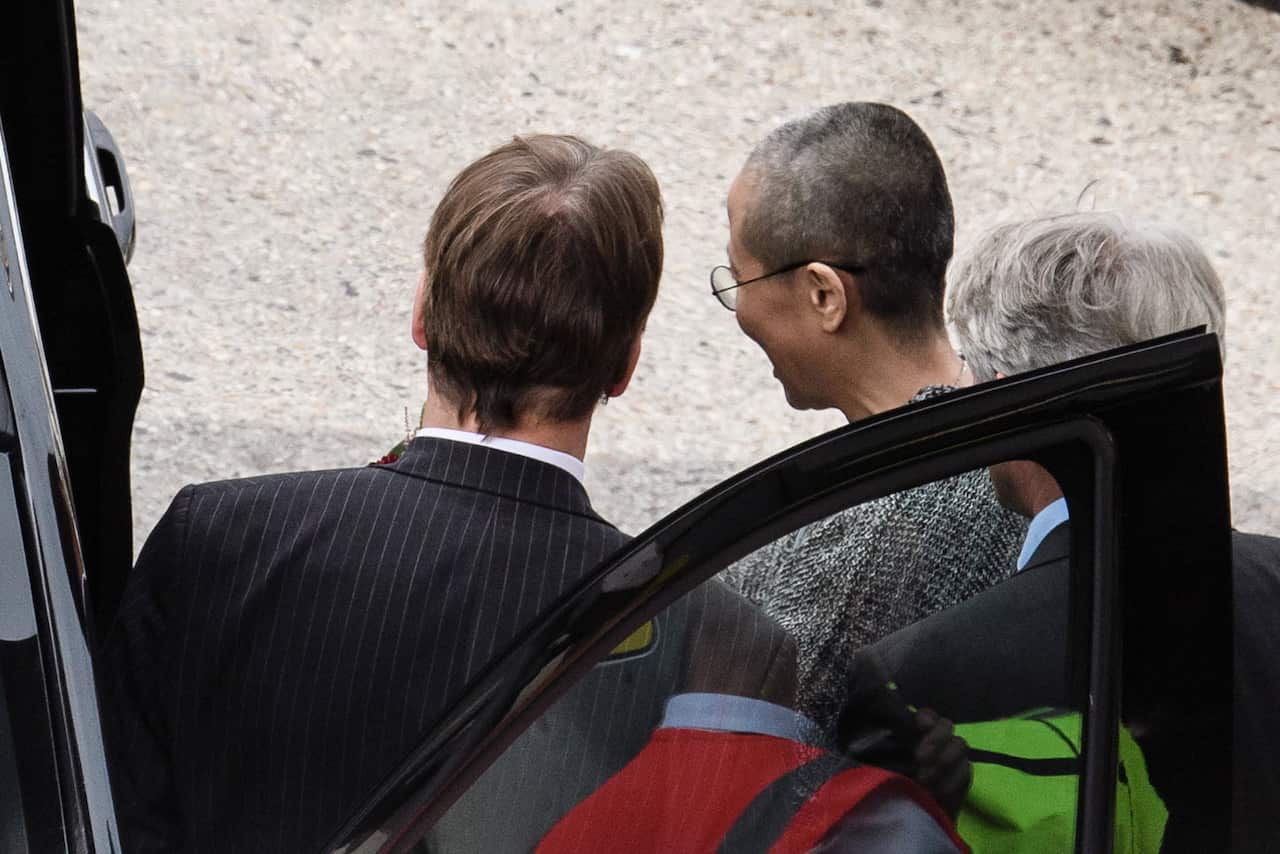 Liu Xia (C), enters a car on the air field after her arrival at the airport in Berlin. 