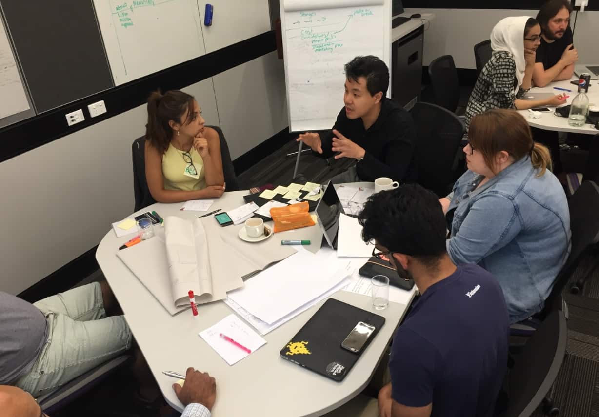 Alpha Cheng with his group discussing how to encourage positive conversations (SBS)