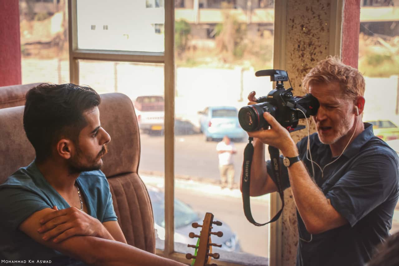 Amos Roberts filming with Khalid Waleed, a musician and barber from Mosul.