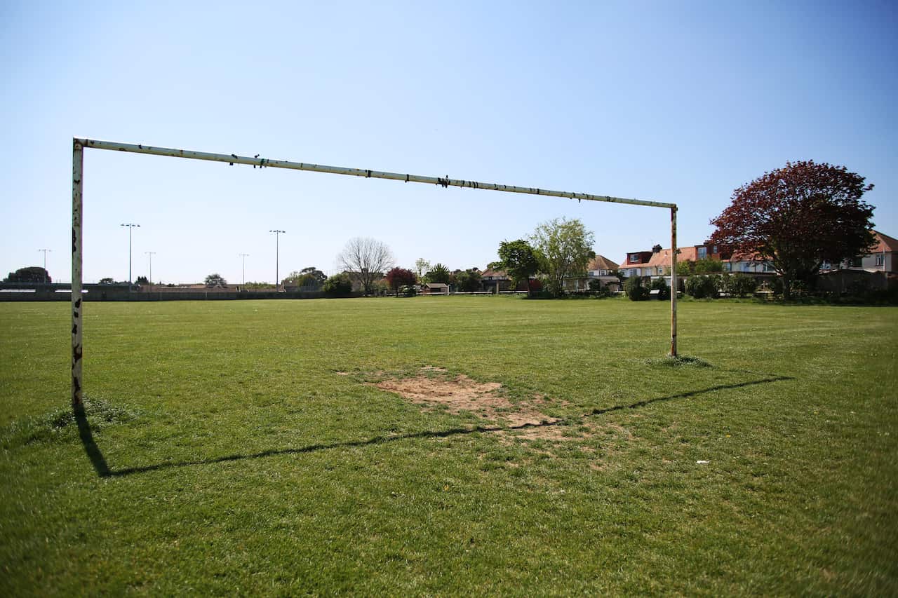 An empty soccer field from the view of behind the goal posts.