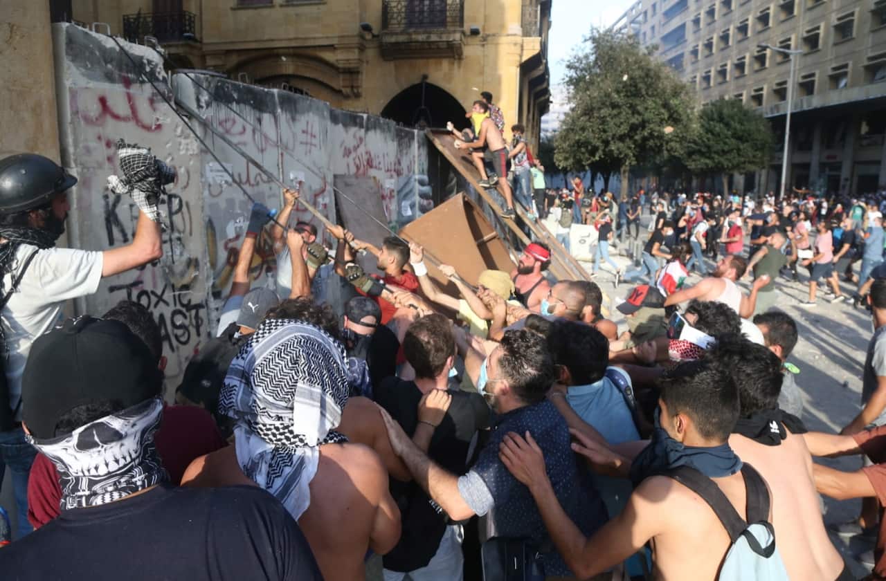 Lebanese anti-government protesters pull a protection wall leading to the Parliament square during a protest in Beirut.