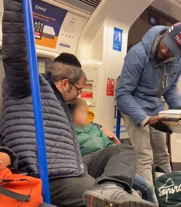 A Jewish man comforts the boy as the man reads anti-Semitic passages on the London Underground.