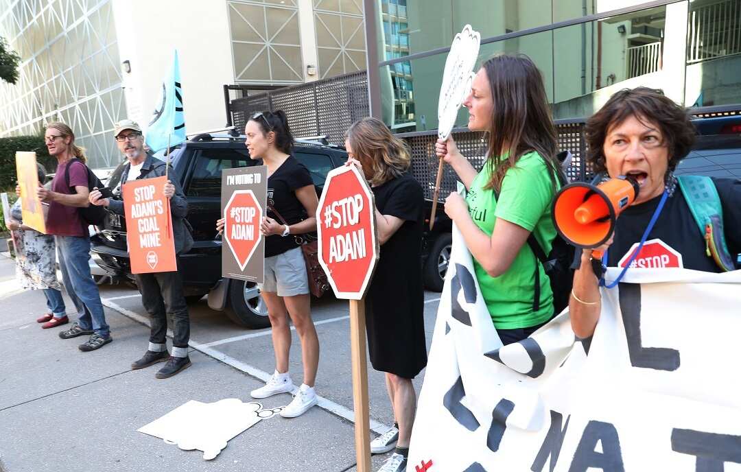 Anti Adani protesters are seen outside a hotel where Australian Prime Minister Scott Morrison announces the government's climate package at a function in Melbourne, Monday, February 25, 2019. (AAP Image/David Crosling) NO ARCHIVING