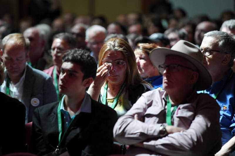 A woman reacts as she watches Prime Minister Scott Morrison deliver the National Apology to victims and survivors of Institutional Child Sexual Abuse.