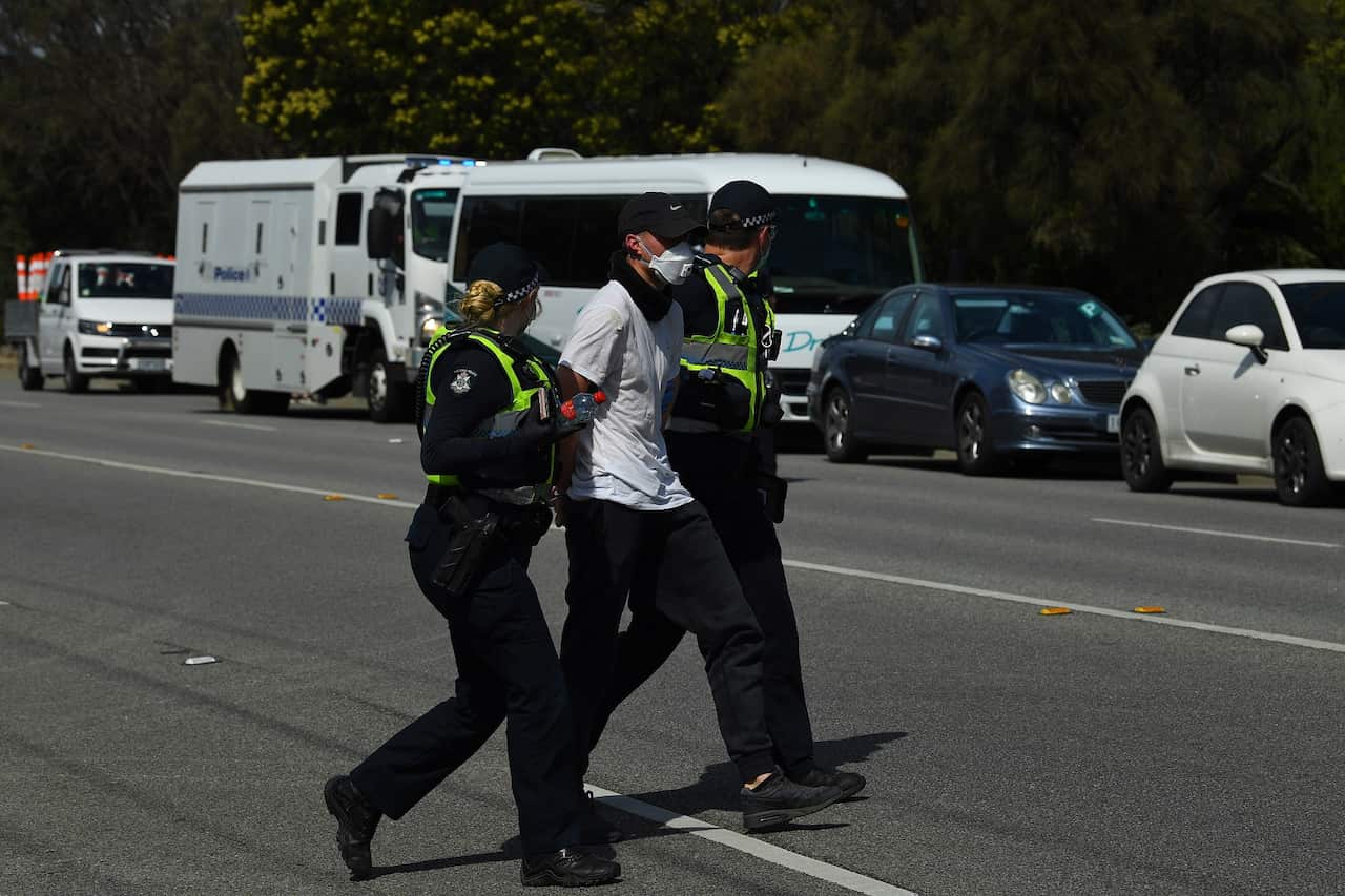 Victoria Police detain a protester near Elwood Beach.                                              