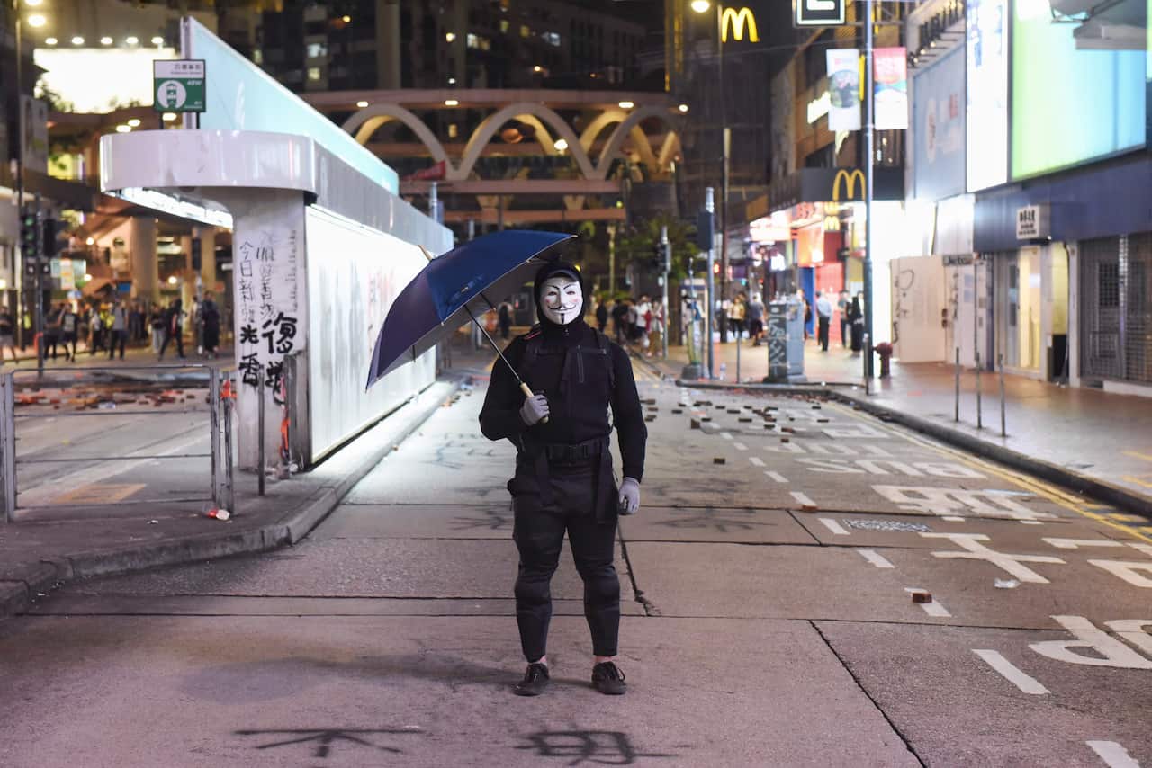 A protester wearing a Guy Fawkes mask at pro-democracy rally in Hong Kong. Hundreds were arrested by police overnight. 